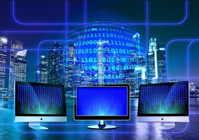 Three desktop screens switched on side by side against a blue digital backdrop